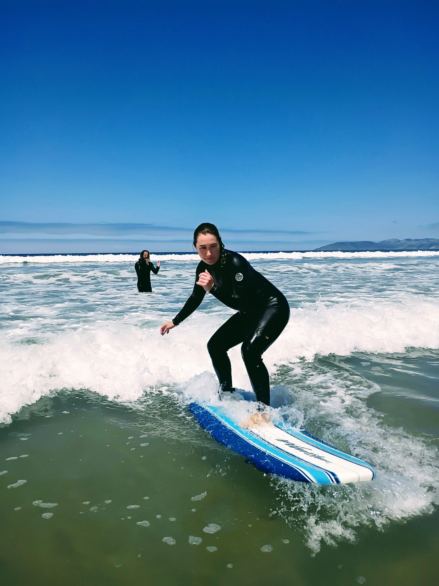 A surfer riding a wave at Pismo Beach on the Central Coast of California